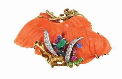 Estimate $1,500-2,000 14 A Coral Fish Pendant/Brooch SEAMAN SCHEPPS 1945 Designed as a carved coral fish, within a gold foliate frame, accented with carved emeralds, cabochon and circular-cut rubies