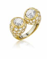 NY34082-4 PROPERTY OF A LADY 32 A Twin Diamond Ring Set with two circular-cut diamonds, to the pavé-set diamond bombé surround, mounted in 18K yellow gold, size 3 1/2.