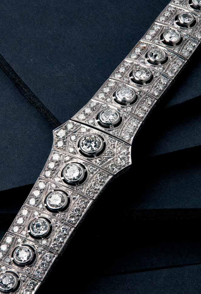 17 33 An early 20th century diamond set bracelet of articulated design, the graduated rectangular panels each collet set with a central round cut