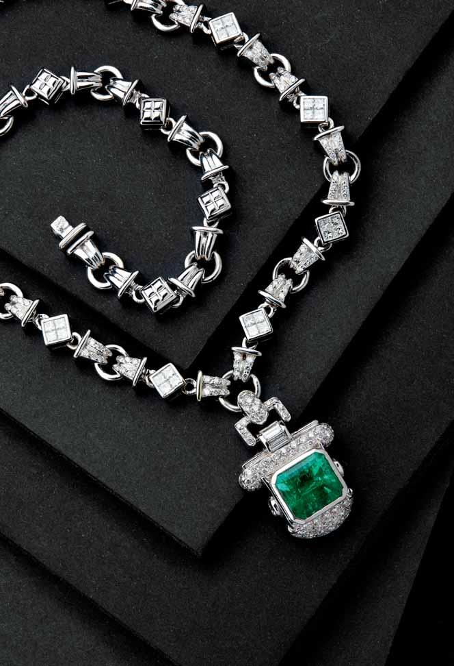 38 85 An Art Deco style emerald and diamond set pendant necklace the pendant collet set with a trap cut emerald, in a shaped surround pavé set with round brilliant cut diamonds, with further baguette