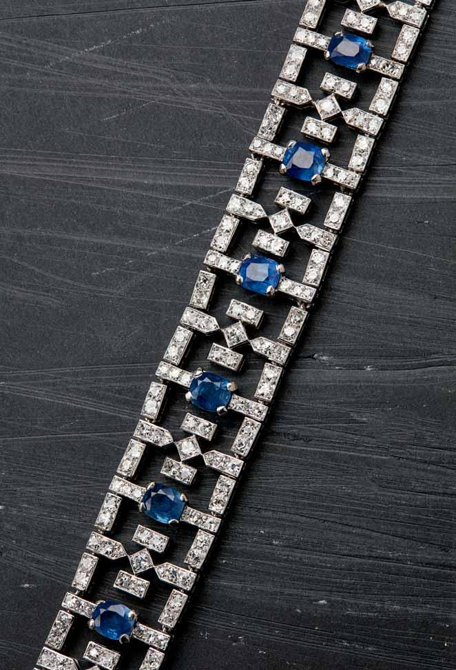 41 94 A sapphire and diamond set bracelet of pierced articulated design, claw set with nine oval cushion cut sapphires in a stylised angular