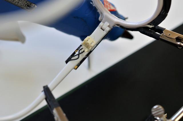 Use hot glue to temporarily affix the battery connector to the frames.
