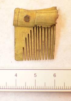 The comb is decorated with vertical parallel lines, horizontal lines across the connecting plate, and faint diagonal lines possible creating the typical diamond decoration.