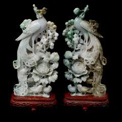 174 Mirrored Pair of Jadeite Phoenix Carvings Elaborately carved in openwork to feature a phoenix along with two smaller birds amongst peony and peaches, wood stands. {Height: 13 1/2 inches (34.