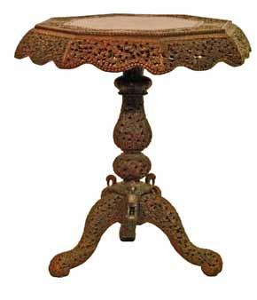 Century Indian carved hardwood scroll arm elbow chair having a slender high back with foliate decoration, hard seat and standing on tapered turned supports, 182cm