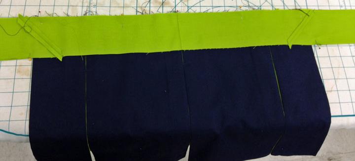 When you have the skirt centered and aligned between the sash pieces, pin in place and continue to pin the length of each