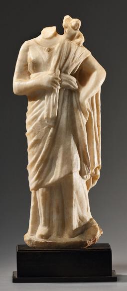, Switzerland, acquired 1980. Attic, ca. 510 B.C. CHF 16,000 A STATUETTE OF VENUS WITH CUPID. H. 27.1 cm. Marble. The goddess stands in a casual pose.