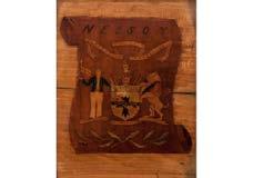 O 453 An Early 19th Century marquetry coat of arms for EARL NELSON the sycamore panel with inlaid fruitwood on scroll-form ground entitled NELSON -- (30.5 x 22.2cm.