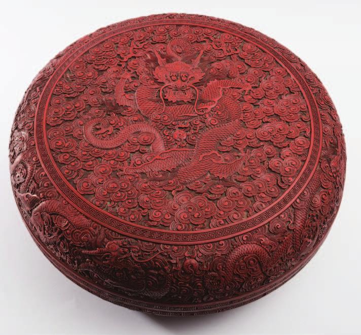 733 733 A fine and large Chinese red cinnabar lacquer Dragon box and cover of circular form, the domed cover carved with a five-clawed dragon writhing around a flaming pearl surrounded by cloud