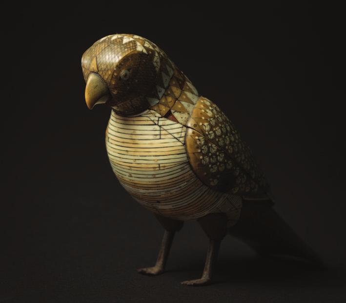 803 A Persian ivory, mother of pearl and horn mounted wood box and cover in the form of a parrot, it s plumage inlaid in naturalistic and geometric style, the