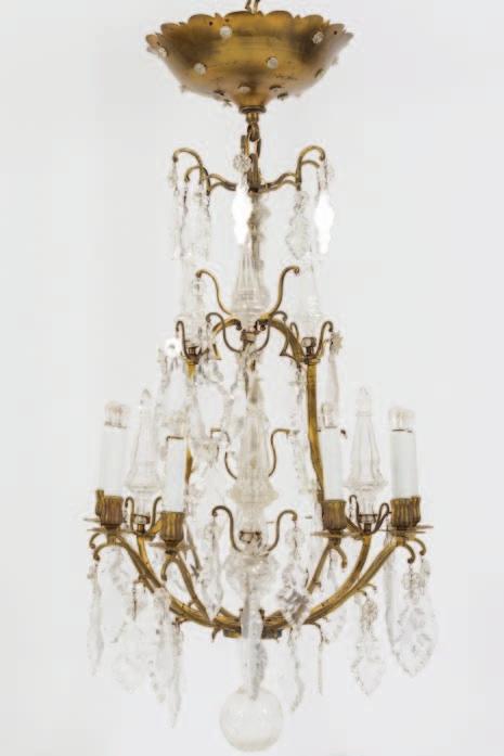 200-250 848 A gilt metal nine-branch chandelier with domed corolla inset with glass flowerhead decoration, the branches with faceted clear glass drops and prisms on a central glass stem and gilt
