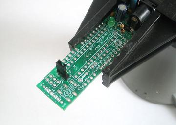 Place the jumper/shunt as shown, so that its on the EXT pair of pins. Take the board out of the vise and plug in a power source such as a 9V DC positive-tip wall adapter or a 9V battery with a 2.
