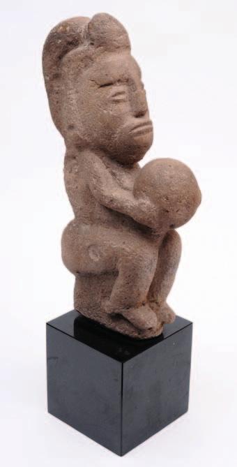 573. A Mayan volcanic rock figure depicting a ball game player, the seated figure holding the ball between both hands, 44.5cm high on later black marble pedestal.