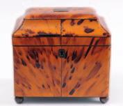 An early 19th century blonde tortoiseshell tea caddy of rectangular form, the domed hinged lid enclosing two lidded
