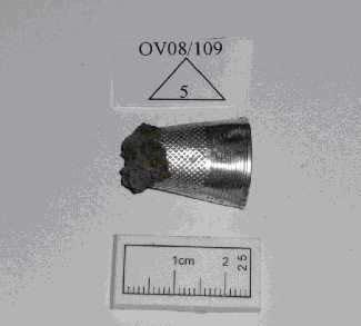 Candidate No: 63702 Metal Objects Silver 0V08110915 - A silver thimble with an encrustation of iron oxide to the tip was recovered from a top soil context. The item is slightly compressed.