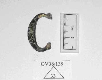 This item was recovered from a top soil context. Photo 31 Copper alloy buckle 4. 008/139/33 - Part of a copper alloy oval buckle with traces of gold leaf and the word Amor inscribed.