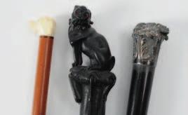640 641 640 A Victorian ebonised walking cane, the handle carved in the form of a pug dog, another cane walking stick with carved ivory dog s head handle and an ebonised and silver mounted walking