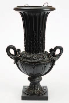 663 663 A 19th Century bronze twinhandled campana urn of slender, flared and fluted form, with reeded scroll handles and all over foliate decoration, raised on a square base, together with copper