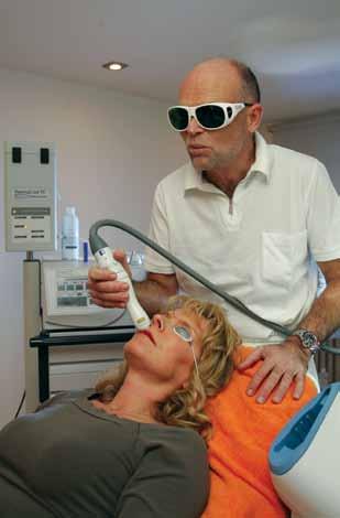 Cosmetic Surgery Doctor Michael Krueger uses a laser on a