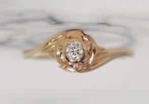 00 14kt rose gold ring with a single bezel set round diamond