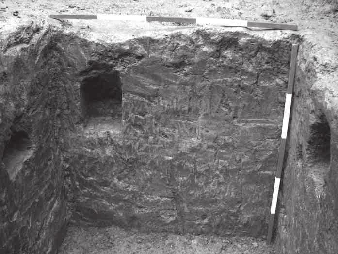 Figure 25. Three of the beam slots in the walls of the well. Facing west, scales 1 m.