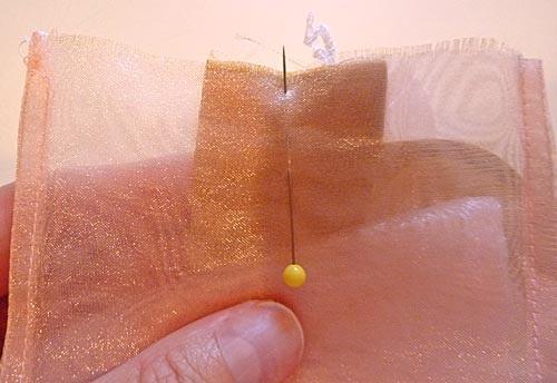 4. Make two pleats in the organza tie, bringing the sides of the tie in to the center so the organza tie is now the same width as the taffeta waistband "tab." 5.