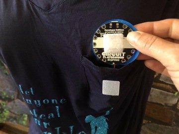 Slip the battery in the pocket and attach the Circuit Playground Express to the velcro. Cut a circle "moon" out of holographic sticky-back vinyl.