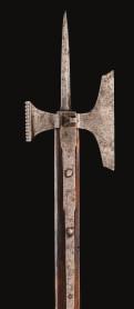 131 132 131 A RARE LATE GOTHIC POLE-AXE, GERMAN OR SWISS, FIRST QUARTER OF THE 16TH CENTURY with central spike of diamond section continuing at the base to form a pair of long straps, axe blade