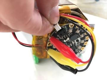 Use a square of double sided tape to stick the Circuit Playground Express the to back