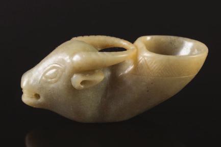 645 646 645 A Chinese carved jade ox s head rhyton the animal with open mouth and carved diaper band to it s upturned neck, the stone of grey