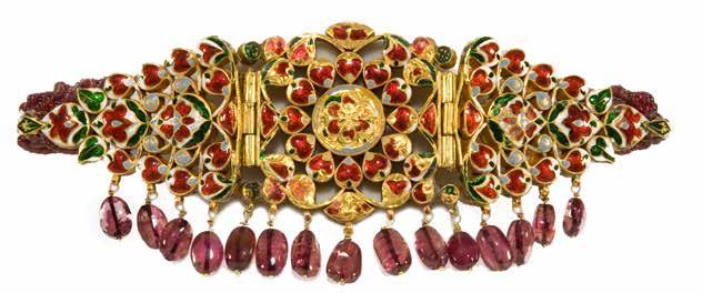 The center rosette is surrounded by small curving leafy sprays, bordered by a vertical band on either side, kundan set with cabochon rubies.
