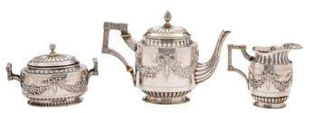 271 A Continental silver three piece tea service, bears Dutch import marks of oval outline with embossed ribbon tied garland decoration, raised on an oval foot, total weight of silver 32.