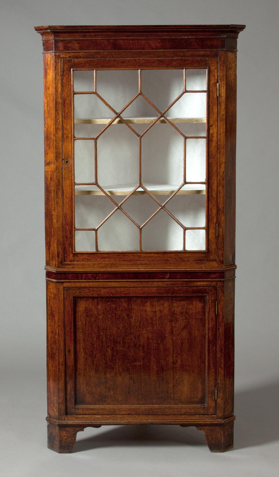 4 Small corner cupboard 1350 Cwpwrdd cornel bychan A Welsh corner cupboard, which is made from oak with a cross banded mahogany frieze above both the single astragal glazed door and