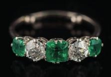 501 An emerald and diamond five-stone ring with three emerald-cut emeralds approximately 4.2mm, 5.5mm and 4.