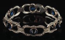 405 A mid 20th century blue and white paste-set bracelet with six rectangular links, each with a central blue cabochon paste within a