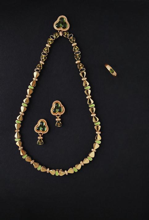 68 Lyon & Turnbull 185 MOUAWAD - A peridot and diamond set suite comprising a necklace, pendant earrings and ring; the necklace composed of bow shaped links with green enamel and diamond set detail,