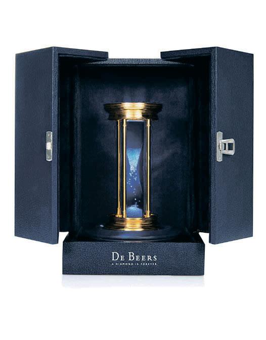 2001 2001 DE BEERS A GOLD PLATE HOURGLASS WITH FLOATING DIAMONDS CIRCA 2000 Containing approximately 2000 natural rough diamonds, weighing approximately 35 carats, suspended in clear fluid, gold