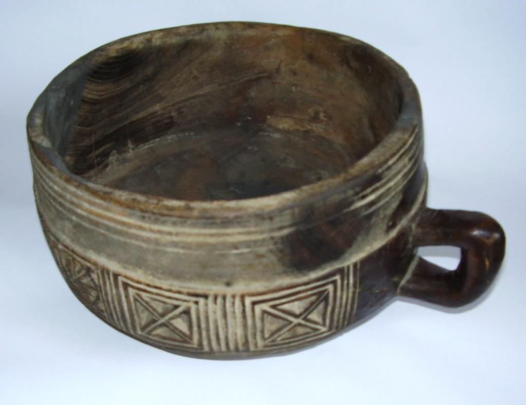 Vessel 2005.739 Bowl Wood / hand-crafted Carved flat-bottomed bowl, with slightly curved straight sides, on small flat base. Four concentric incised lines around outer rim.