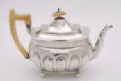 450-500 107 A George III silver tea pot, maker TJ, London, 1807, of half fluted oblong form, ivory handle and finial, on four ball feet, 16.5cm high, 18.5ozs.