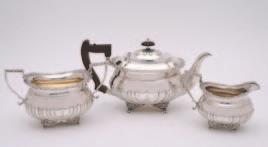 400-500 19 An Edwardian three piece silver tea set, maker Thomas Bradbury & Sons, London, 1905, of half fluted oval rounded form, with chased foliate