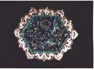 Figure 4. Brooch with carved slice from emerald crystal as center stone. Emerald measures 9.1 m m x 50.8 mm x 40.35 mm. thin section of a crystal for personal adornment.