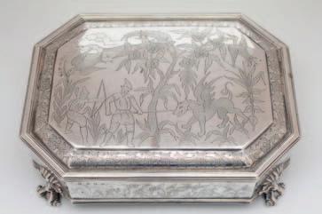300-400 65 An Edward VII Irish silver cigar casket, maker West & son, Dublin 1903, the hinged lid and sides engraved with a mythical hunting scene, raised on scroll feet, 59.09oz.