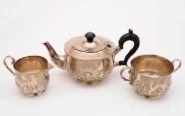 17 A George V silver three piece tea set, maker Charles Edwards, London 1919, having overall hammered decoration with shaped handles, and a
