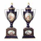 1328 Pair Meissen Style Porcelain Covered Urns early 20th century, pedestal base supporting covered urn, cobalt ground, one side of each with enamel and giltlined hand-painted figural reserve, the