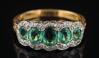 272 An 18ct yellow gold, emerald and diamond ring with graduated, oval emeralds within a surround of single-cut diamonds in white metal setting, largest emerald measures approximately 5.9mm long x 4.