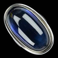 100-150 124 A LARGE SILVER AND SYNTHETIC SAPPHIRE RING, BY HARALD NIELSEN, FOR GEORG JENSEN, MID 20TH CENTURY, the oval cabochon blue synthetic sapphire collet set within polished surround, to