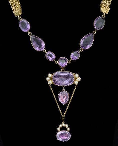 126 AN AMETHYST NECKLACE, composed of linked open backed pinched collet set oval and pear-shaped mixed-cut amethysts, to gold multi strand Albertina back chains, to amethyst clasp, suspending a