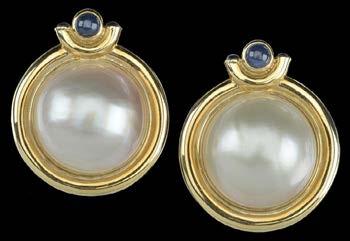 151 A PAIR OF LARGE MABE PEARL EARCLIPS, the large hemispherical pearls within polished yellow precious metal mounts, with cabochon sapphire set