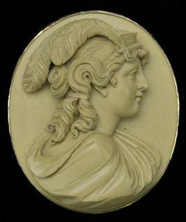 202 A 19TH CENTURY OVAL LAVA CAMEO BROOCH, carved in high relief to depict a Classical goddess in profile, wearing a diadem and with plumes to her hair, possibly depicting the Goddess of Liberty,