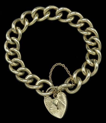 209 A 9CT GOLD SOLID CURB-LINK CHAIN BRACELET, with heart-shaped padlock clasp, hallmarked for London, 1965, bracelet length 19cm, weight 64gm.